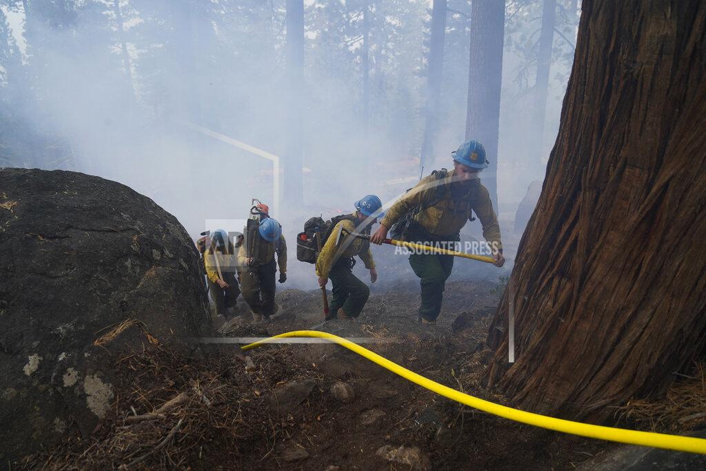 Jae C. Hong Members of a hotshot crew hike up the mountain while battling the Caldor Fire in South Lake Tahoe, Calif., Friday, Sept. 3, 2021. Fire crews took advantage of decreasing winds to battle a California wildfire near popular Lake Tahoe and were even able to allow some people back to their homes but dry weather and a weekend warming trend meant the battle was far from over. (AP Photo/Jae C. Hong)