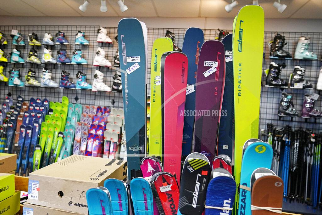 Charles Krupa Skis and boots are displayed in the ski shop at McIntyre Ski Area, Wednesday, Dec. 16, 2020, in Manchester, N.H. Over the summer, people looking to get out of the house snapped up boats, bicycles and patio furniture, figuring they were safer socializing and being active outdoors than inside. Now that temperatures are dropping, they're buying snowshoes, skis, boots and winter coats, boosting the beleaguered retail sector. (AP Photo/Charles Krupa)