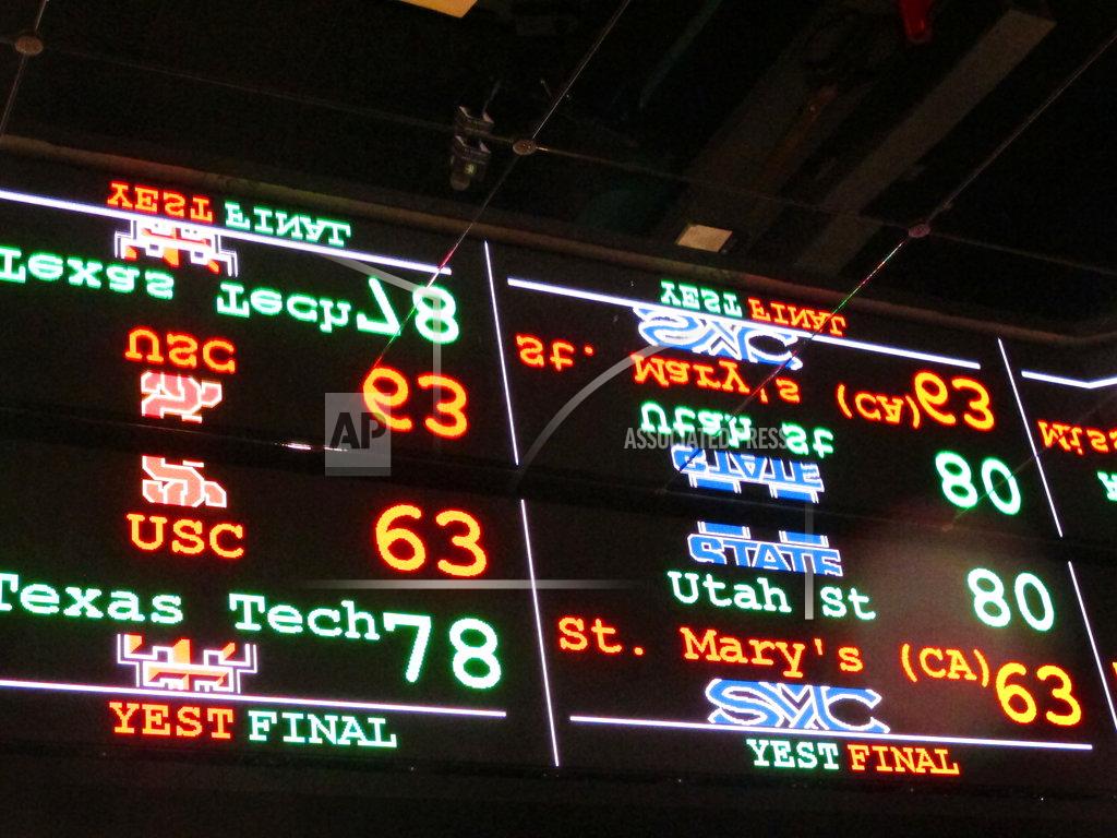 FILE This Nov. 20, 2018 file photo shows a scrolling video board with basketball scores reflected in the ceiling of the new sports book at Resorts Casino in Atlantic City, N.J. The race to legalize sports betting is on now that the U.S. Supreme Court has allowed it in all 50 states, but will it provide enough extra tax revenue to make much of a difference for schools, roads or pension debt? (AP Photo/Wayne Parry)