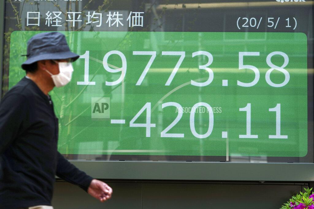 Eugene Hoshiko A man walks past an electronic stock board showing Japan's Nikkei 225 index at a securities firm in Tokyo Friday, May 1, 2020. Shares have dropped in Asia after Wall Street ended its best month in 33 years with losses on fresh news of economic carnage from the coronavirus pandemic. (AP Photo/Eugene Hoshiko)