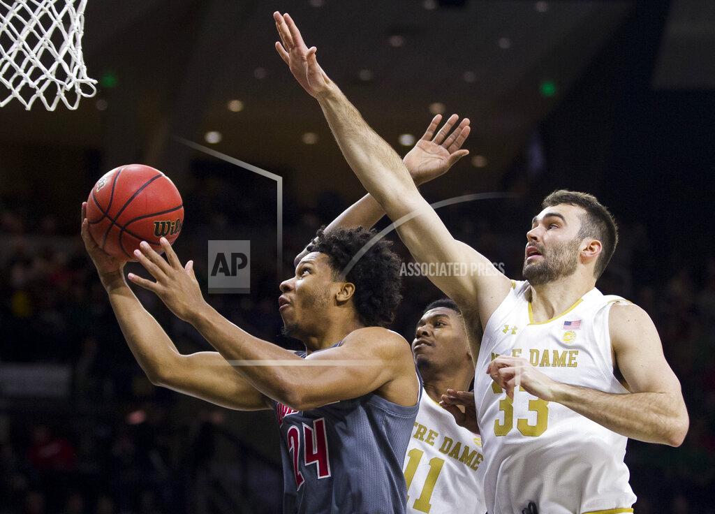 Robert Franklin Louisville's Dwayne Sutton (24) goes up for a shot in front of Notre Dame's Juwan Durham (11) and John Mooney (33) during the first half of an NCAA college basketball game Saturday, Jan. 11, 2020, in South Bend, Ind. (AP Photo/Robert Franklin)