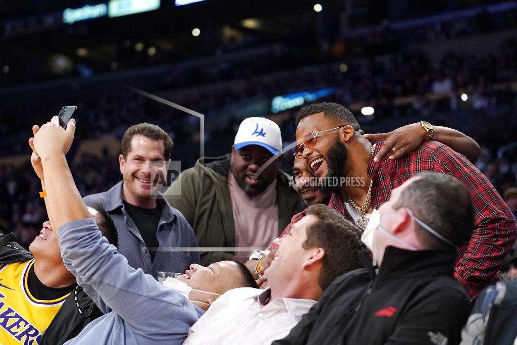 Mark J. Terrill Aaron Donald of the Los Angeles Rams, upper right, poses with fans during the second half of an NBA basketball game between the Los Angeles Lakers and the Utah Jazz Wednesday, Feb. 16, 2022, in Los Angeles. The Lakers won 106-101. (AP Photo/Mark J. Terrill)