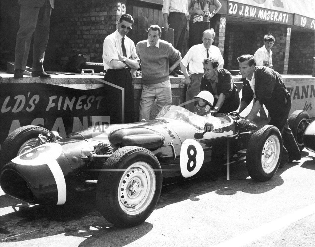 Anonymous FILE - In this file photo dated July 6, 1961, Stirling Moss, at the wheel of the revolutionary new Ferguson racing car, gets a shove off from mechanics as he takes the green racer out for some practice laps at Silverstone, England. The Ferguson car, which has four-wheel drive and a new nonskid braking system, will be driven by Jack Fairman in the upcoming British Empire trophy race and Moss will drive a Cooper in the race. Stirling Moss has died at the age of 90, according to an announcement Sunday April 12, 2020, from his family. (AP Photo, FILE)