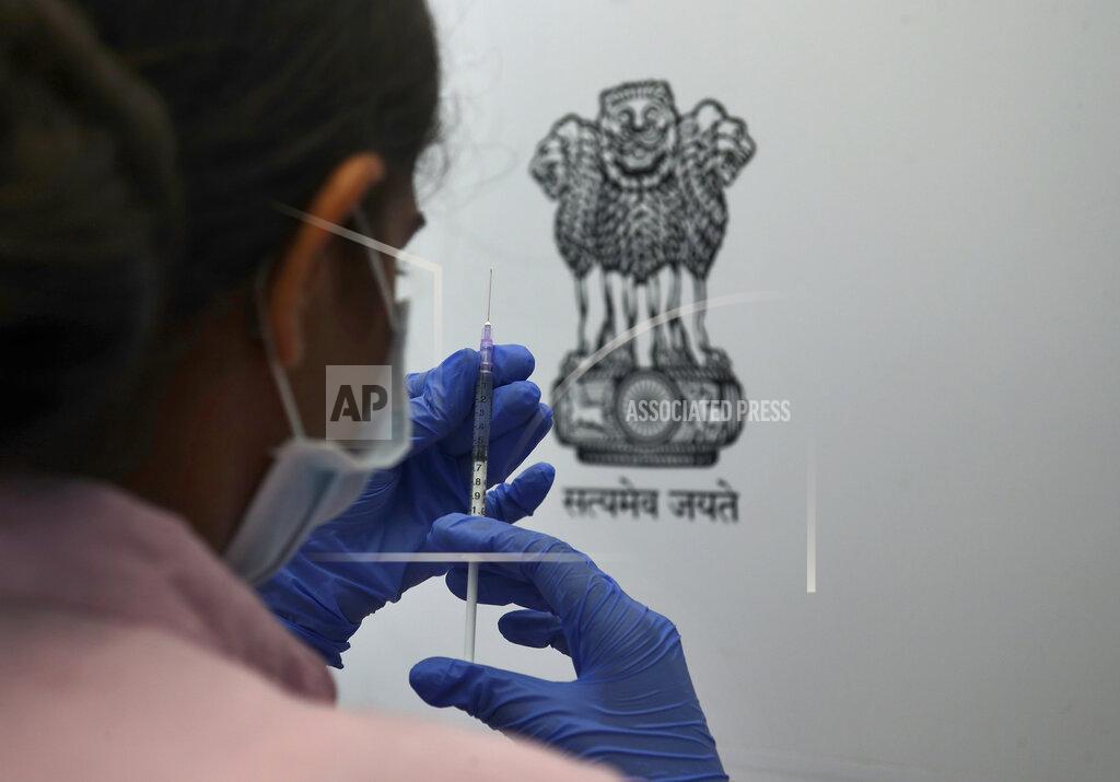 Mahesh Kumar A FILE - In this May 17, 2021, file photo, a health worker prepares to administer the Sputnik V coronavirus vaccine to a man next to India's state emblem during a soft launch of the Russian vaccine by inoculating employees and families of Dr Reddy's Laboratories in Hyderabad, India. The disparities of the coronavirus pandemic were already stark in India, where access to health care is as stratified and unequal as other parts of its society. Now, the divide along the lines of wealth and technology are further widening that chasm, and many people are falling through the gaps as vaccines remain inaccessible to millions. (AP Photo/Mahesh Kumar A, File)