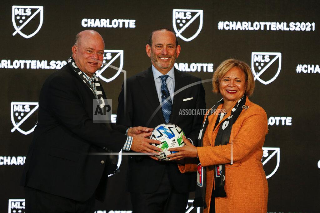 Nr Major League Soccer Commissioner Don Garber, left, Charlotte MLS owner David Tepper, center, and Charlotte mayor Vi Lyles pose for a photo after announcing the MLS will have a team in Charlotte in 2021 at an event in Charlotte, N.C., Tuesday, Dec. 17, 2019. (AP Photo/Nell Redmond)