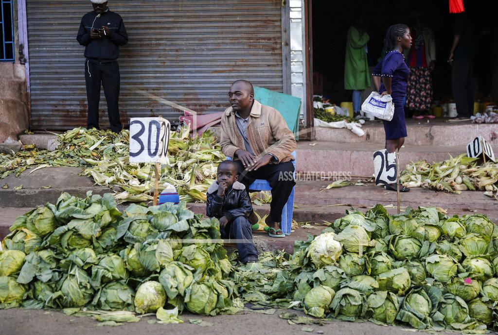 Brian Inganga In this photo taken Tuesday, March 24, 2020, a street trader sells cabbages by the side of the road, after the government ordered the closure of the main open air market, in the Mathare slum, or informal settlement, of Nairobi, Kenya. Many slum residents say staying at home or social-distancing is impossible for those who live hand to mouth, receiving daily wages for informal work with no food or economic assistance from the government, as is maintaining sanitation where a pit latrine can be shared by over 50 people. The new coronavirus causes mild or moderate symptoms for most people, but for some, especially older adults and people with existing health problems, it can cause more severe illness or death. (AP Photo/Brian Inganga)