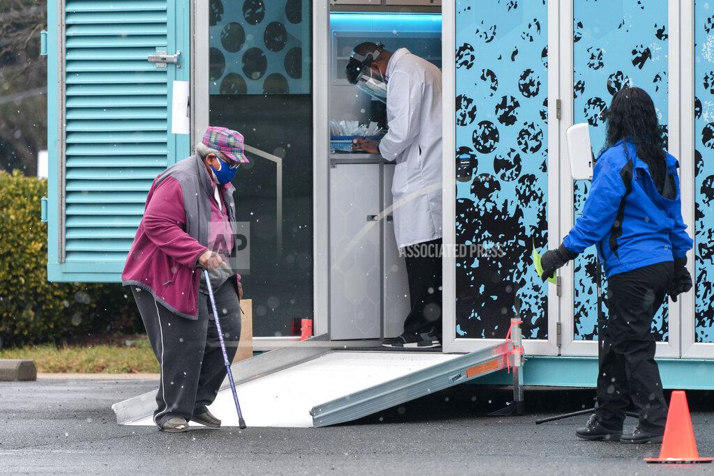 Jacquelyn Martin In this Thursday, Feb. 11, 2021, photo a woman arrives at a COVID-19 vaccination clinic outside the Pennsylvania Avenue Baptist Church, Thursday, Feb. 11, 2021, in southeast Washington. (AP Photo/Jacquelyn Martin)