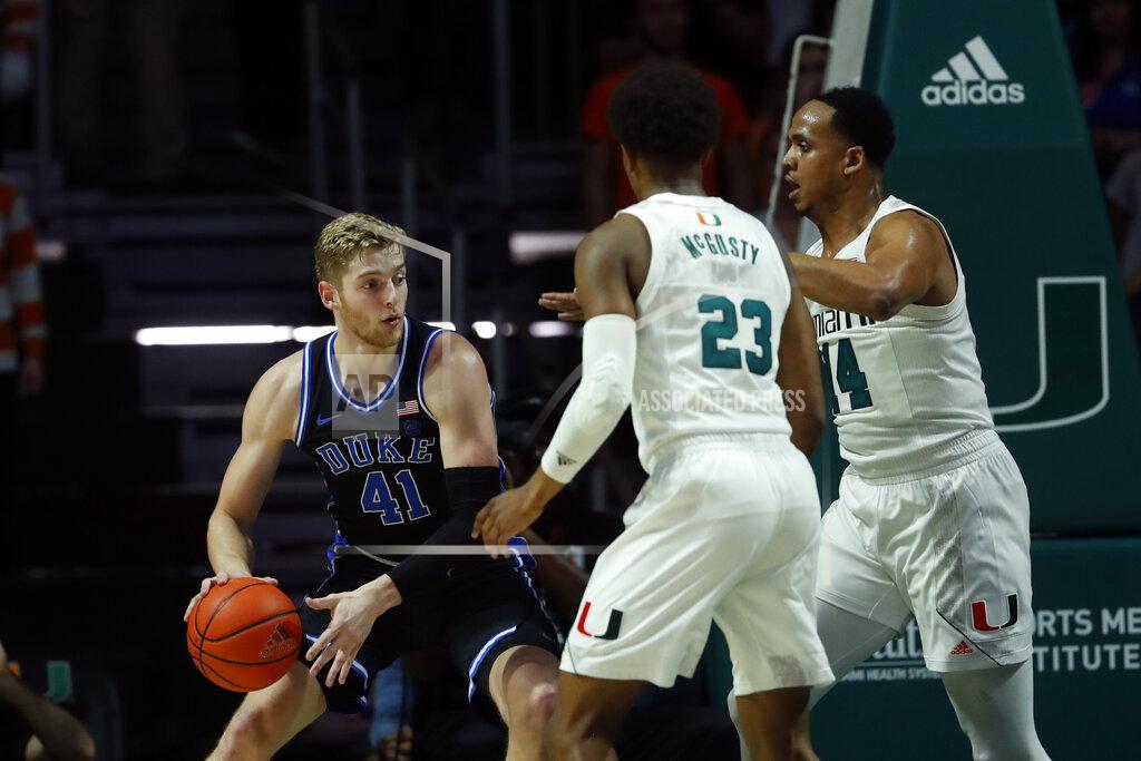 Wilfredo Lee Duke forward Jack White (41) looks for an opening past Miami guard Kameron McGusty (23) and center Rodney Miller Jr. (14) during the first half of an NCAA college basketball game, Saturday, Jan. 4, 2020, in Coral Gables, Fla. (AP Photo/Wilfredo Lee)