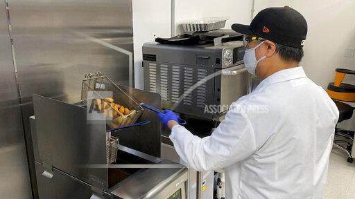 Nathan Foot, R&D chef at Impossible Foods, takes its new meatless nuggets out of a deep fryer in the company’s test kitchen on Sept. 21, 2021 in Redwood City, Calif. The plant-based nuggets taste are designed to taste like chicken. (AP Photo/Terry Chea)