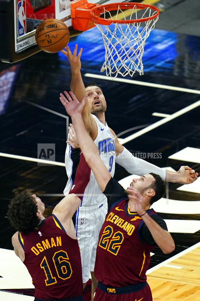 John Raoux Orlando Magic center Nikola Vucevic, center, goes up for a rebound against Cleveland Cavaliers forward Cedi Osman (16) and forward Larry Nance Jr. (22) during the first half of an NBA basketball game, Monday, Jan. 4, 2021, in Orlando, Fla. (AP Photo/John Raoux)