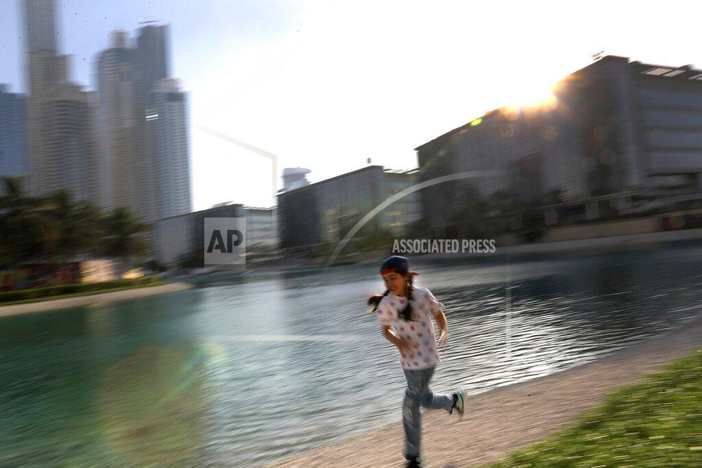Kamran Jebreili Michelle Rasul enjoys a run along a lake in Dubai, United Arab Emirates, Sunday, May 9, 2021. Rasul, a 9-year-old girl from Azerbaijan who lives in Dubai, is scratching her way to the top as a DJ after competing in the DMC World DJ Championship. (AP Photo/Kamran Jebreili)
