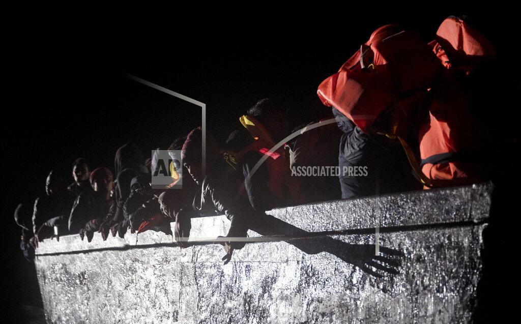 Valeria Ferrario Dozens of migrants sit in a wooden boat off the waters of Tunisia early Wednesday, May 25, 2022. Some 110 people were rescued by the non-governmental organization Open Arms during a mission in the Mediterranean Sea after their boat capsized. (AP Photo/Valeria Ferraro)
