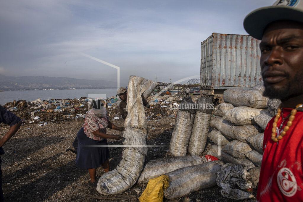 Rodrigo Abd A woman packs charcoal to sell at a market in downtown Port-au-Prince, Haiti, Wednesday, Sept. 22, 2021. Deportees join thousands of fellow Haitians who have been displaced from their homes, pushed out by violence to take up residence in crowded schools, churches, sports centers and makeshift camps among ruins. (AP Photo/Rodrigo Abd)