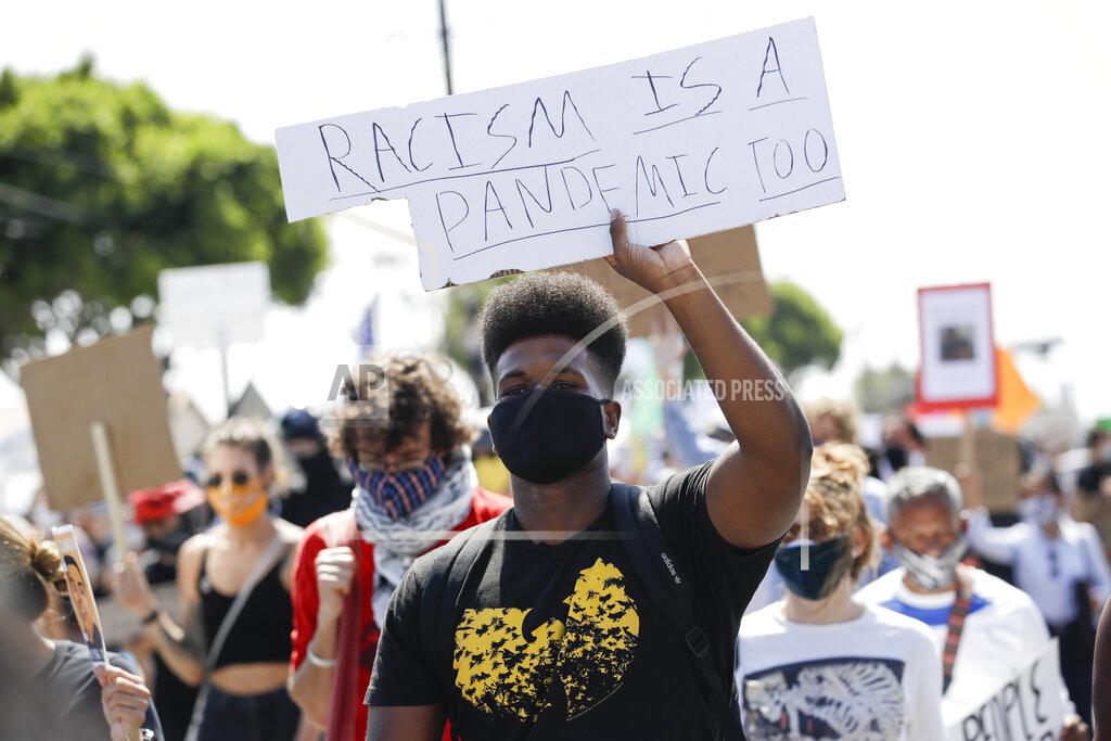 Marcio Jose Sanchez FILE - In this June 21, 2020, file photo, a protester carries a sign during a march in honor of Andres Guardado in Compton, Calif. A national coalition of labor unions, along with racial and social justice organizations, will stage a mass walkout from work July 20, as part of an ongoing reckoning on systemic racism and police brutality in the U.S. (AP Photo/Marcio Jose Sanchez, File)