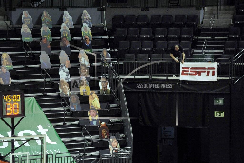 Andy Nelson A member of the ESPN crew takes down a sign after the NCAA college basketball game between Oregon and UCLA cancelled, Wednesday, Dec. 23, 2020, at Matthew Knight Arena in Eugene, Ore. (AP Photo/Andy Nelson)