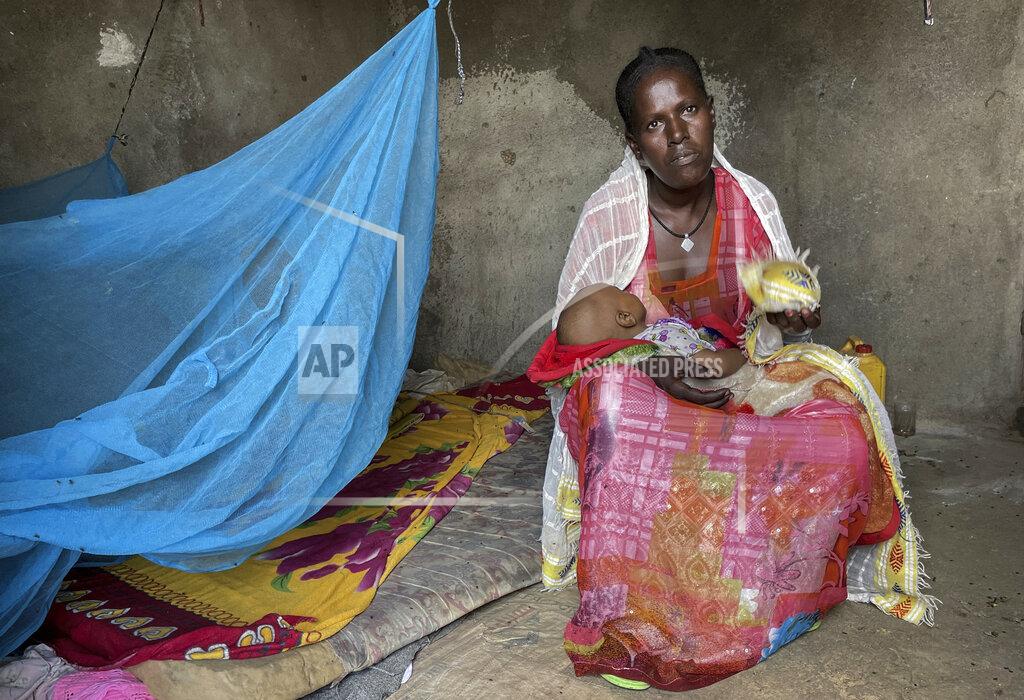 Claire Nevill Letemariam, a mother of six, sits with her baby who was born in a former camp for Eritrean refugees now used by internally-displaced Tigrayans, after escaping fighting in her home town in western Tigray, in the Hitsats camp in the Tigray region of northern Ethiopia Saturday, Aug. 21, 2021. Letemariam was 7 months pregnant when her village was attacked and she and her five children fled on foot with only the clothes on their backs. (Claire Nevill/WFP via AP)