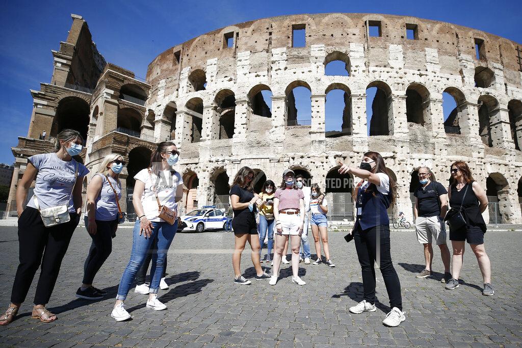 Cecilia Fabiano Tourists wear face masks to curb the spread of COVID-19 as they listen to a tour guide outside the ancient Colosseum, in Rome, Friday, May 21, 2021. The easing of travel restrictions this week have favored travel and tourism. (Cecilia Fabiano/LaPresse via AP)