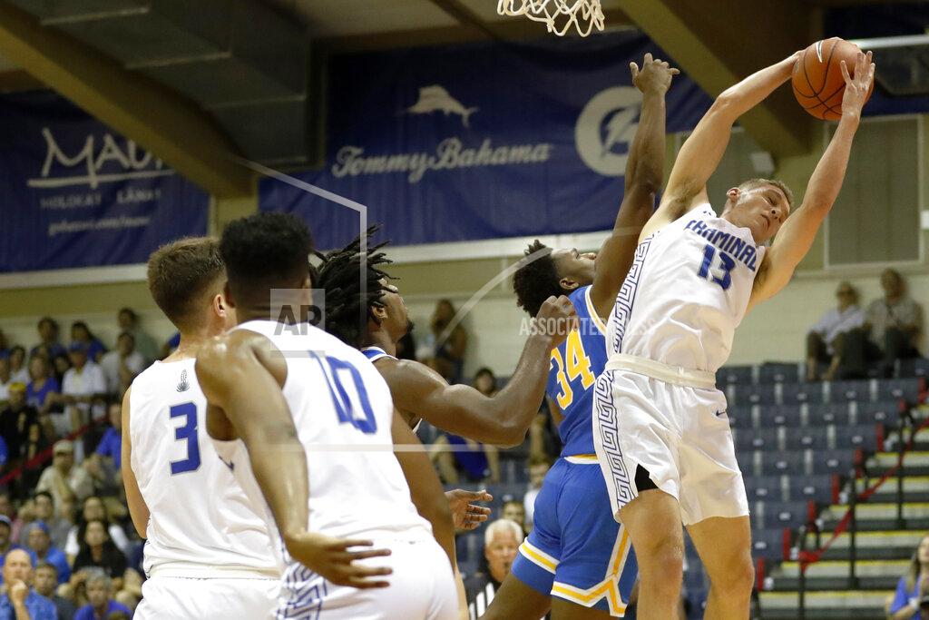 Marco Garcia Chaminade guard Tyler Cartaino (13) grabs a rebound away from UCLA guard David Singleton (34) during the first half of an NCAA college basketball game Tuesday, Nov. 26, 2019, in Lahaina, Hawaii. (AP Photo/Marco Garcia)