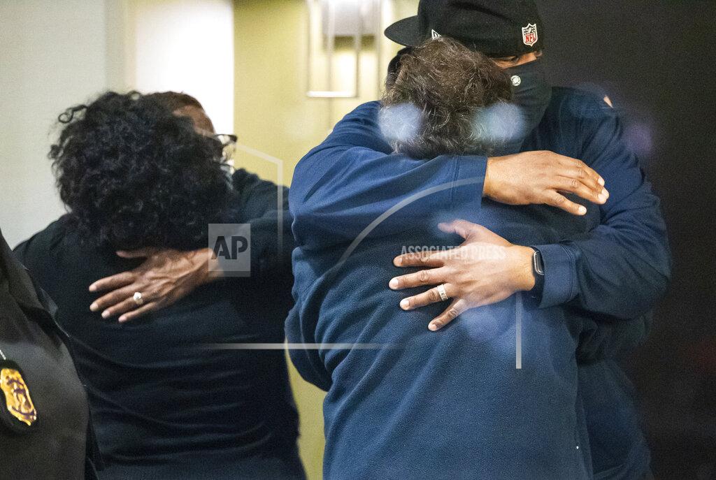 Uncredited People hug after learning that their loved one is safe after a shooting inside a FedEx building Friday, April 16, 2021. Multiple people were shot and killed in a late-night shooting at a FedEx facility in Indianapolis, and the shooter killed himself, police said.(The Indianapolis Star via AP)
