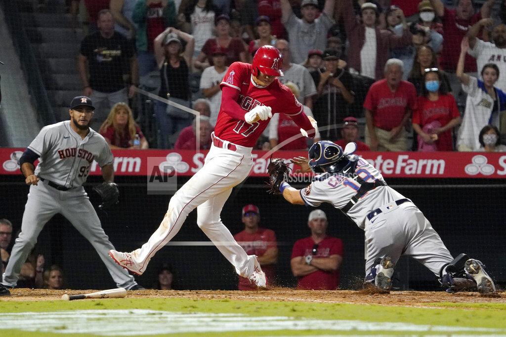 Mark J. Terrill Los Angeles Angels designated hitter Shohei Ohtani, center, avoids a tag by Houston Astros catcher Jason Castro, right, but misses the plate as relief pitcher Yimi Garcia watches during the 10th inning of a baseball game Wednesday, Sept. 22, 2021, in Anaheim, Calif. Ohtani was later tagged out by Castro. (AP Photo/Mark J. Terrill)