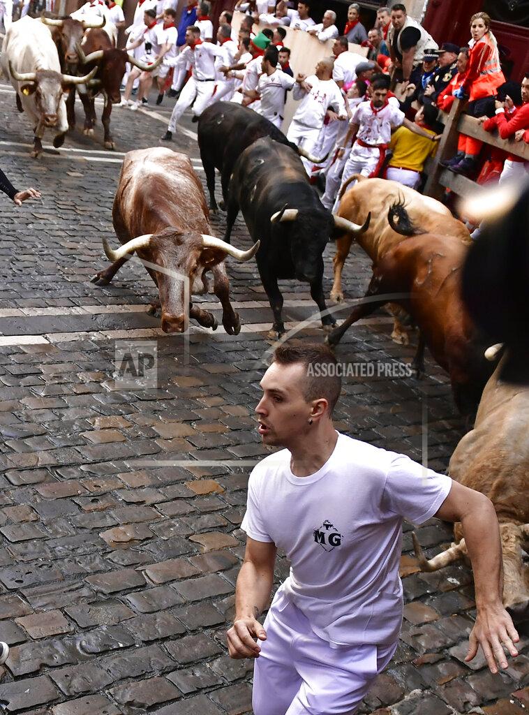 Alvaro Barrientos People run through the streets with fighting bulls and steers during the first day of the running of the bulls at the San Fermin Festival in Pamplona, northern Spain, Thursday, July 7, 2022. Revelers from around the world flock to Pamplona every year for nine days of uninterrupted partying in Pamplona's famed running of the bulls festival which was suspended for the past two years because of the coronavirus pandemic. (AP Photo/Alvaro Barrientos)