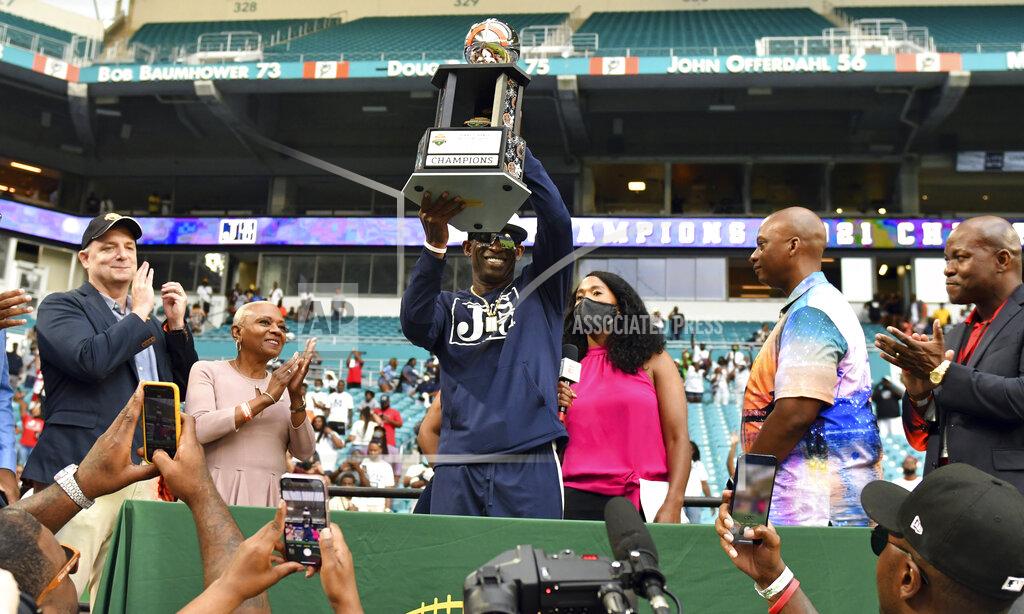 Jim Rassol Jackson State head football coach Deion Sanders, center, holds the Orange Blossom Classic trophy after winning an NCAA college football game over Florida A&M, Sunday, Sept. 5, 2021, in Miami Gardens, Fla. (AP Photo/Jim Rassol)