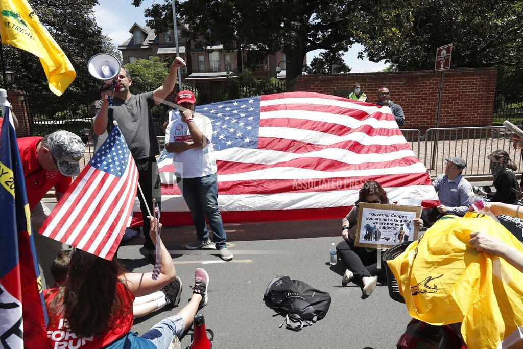 People gather outside the gate of the executive mansion to protest stay-at-home orders due to COVID-19 during a ReOpen NC rally in Raleigh, N.C., Tuesday, May 12, 2020. (AP Photo/Gerry Broome)