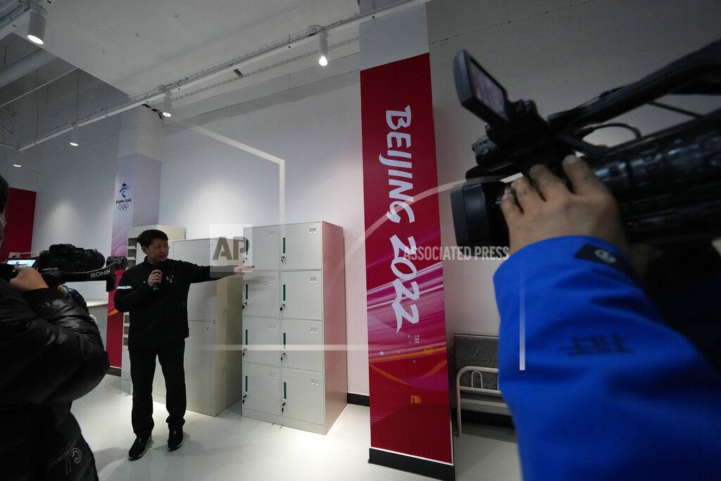 Ng Han Guan A worker displays the furniture to be used for the upcoming Beijing Winter Olympics and Paralympics at the Main Distribution Center built to provide logistic support for the games in Beijing, China, Thursday, Dec. 9, 2021. The 34-meter-tall building has started operation at the end of last year to receive, store and distribute furniture, sport and technical equipment, and other materials for the current test events and next year's Winter Games. (AP Photo/Ng Han Guan)
