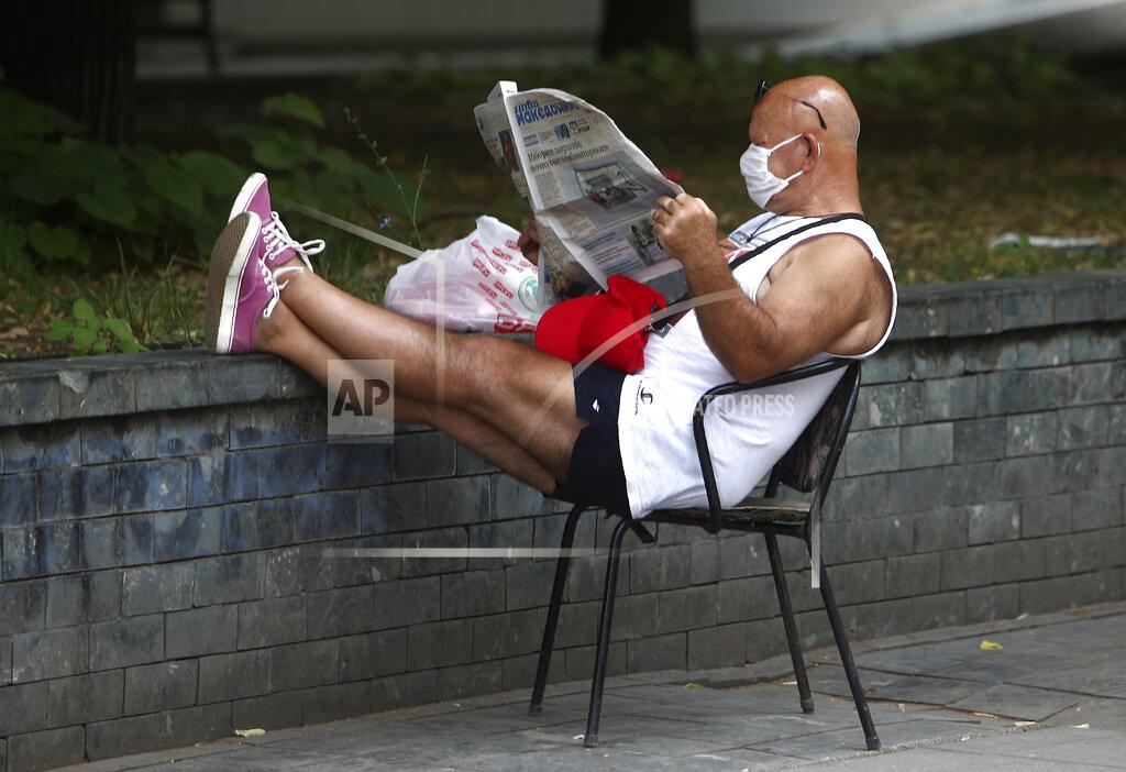 Boris Grdanoski A man reads a newspaper siting in a street in Skopje, North Macedonia on Thursday, July 16, 2020, a day after the country's parliamentary elections. The pro-Western SDSM party in North Macedonia is poised to try to form a coalition government following a narrow election victory. (AP Photo/Boris Grdanoski)