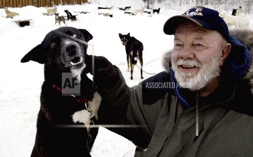 FILE - Author Gary Paulsen sits with his favorite Alaskan husky, Flax, at his Willow, Alaska, home on Feb. 10, 2005. Paulsen died Wednesday, Oct. 13, 2021 at age 82. (AP Photo/Al Grillo, File)