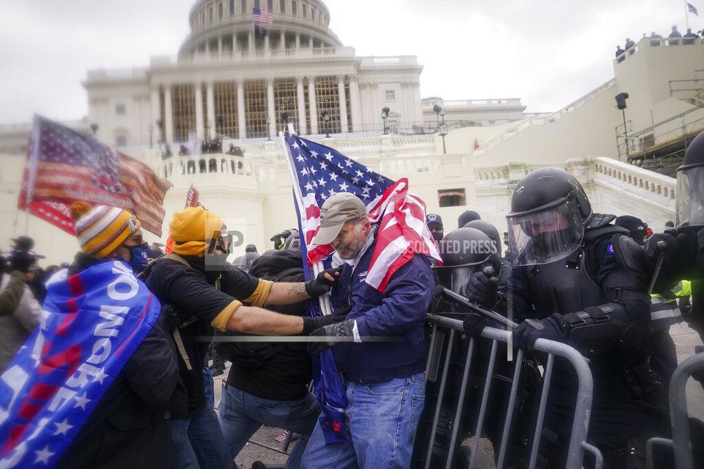John Minchillo FILE - In this Jan. 6, 2021, file photo rioters try to break through a police barrier at the Capitol in Washington. People charged in the attack on the U.S. Capitol left behind a trove of videos and messages that have helped federal authorities build cases. In nearly half of the more than 200 federal cases stemming from the attack, authorities have cited evidence that an insurrectionist appeared to have been inspired by conspiracy theories or extremist ideologies, according to an Associated Press review of court records. (AP Photo/John Minchillo, File)