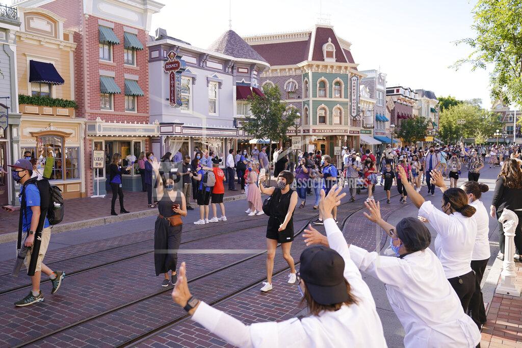 Jae Hong Guests walk down Main Street USA at Disneyland in Anaheim, Calif., Friday, April 30, 2021. The iconic theme park in Southern California that was closed under the state's strict virus rules swung open its gates Friday and some visitors came in cheering and screaming with happiness. (AP Photo/Jae Hong)