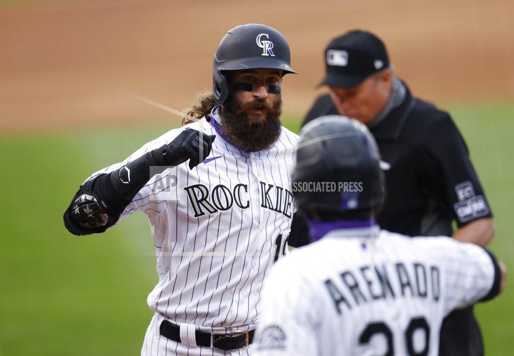 David Zalubowski Colorado Rockies' Charlie Blackmon, back, is congratulated by Nolan Arenado as Blackmon crosses home plate after hitting a two-run home run off San Diego Padres starting pitcher Garrett Richards in the first inning of a baseball game Friday, July 31, 2020, in Denver. (AP Photo/David Zalubowski)