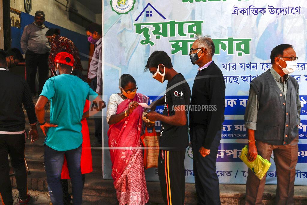 Bikas Das Indians wearing face masks as a precautionary measure against the coronavirus stand in a queue to apply for a health card initiated by West Bengal state government in Kolkata, India, Saturday, Jan. 2, 2021. (AP Photo/Bikas Das)