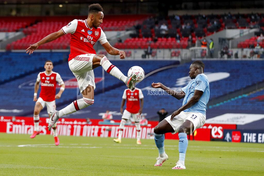 Matt Childs Arsenal's Pierre-Emerick Aubameyang, left, is airborne as he kicks at the ball away from Manchester City's Benjamin Mendy during the FA Cup semifinal soccer match between Arsenal and Manchester City at Wembley in London, England, Saturday, July 18, 2020. (AP Photo/Matt Childs,Pool)