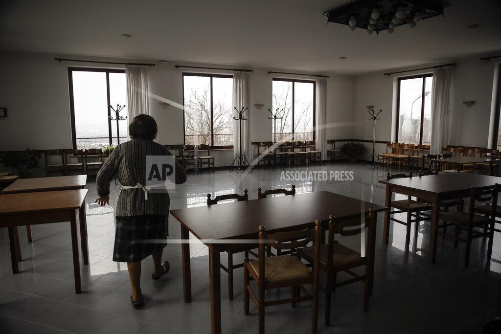 Luca Bruno The owner of a restaurant walks through the dining room, in Vo Euganeo, northern Italy, Wednesday, Feb. 10, 2021. Shockwaves ran through the wine-making village of Vo', west of Venice, as word spread last Feb. 21 that a retired roofer had died of the new coronavirus becoming the first known COVID-19 victim in the West. (AP Photo/Luca Bruno)