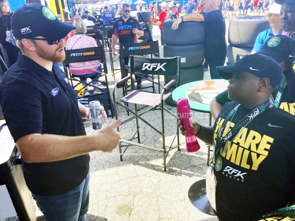 Larry Lage James Bromsey III,right, a sixth-grader at LeBron James' I Promise School in Akron, Ohio, talks with NASCAR driver Chris Buescher, Sunday, Aug. 7, 2022 in Brooklyn, Mich. Bromsey was given an all-access tour of Michigan International Speedway in Brooklyn, Mich., on Sunday. Chris Buescher’s No. 17 Ford had a paint job that highlighted the LeBron James Family Foundation. (AP Photo/Larry Lage)