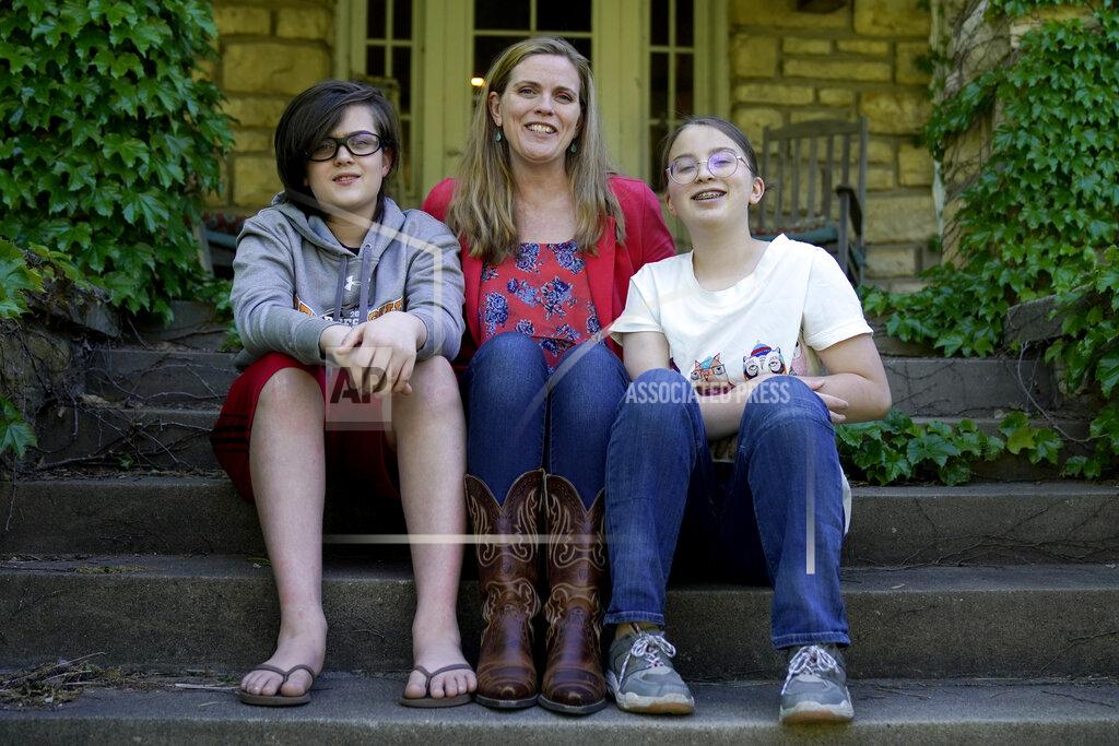 Charlie Riedel Heather Ousley sits with her older children Elliannah, 15, right, and Samuel, 13, in front of their home in Merriam, Kan, Tuesday, May 4, 2021. Ousley was thrilled when she heard the FDA was expected to authorize Pfizer's COVID-19 vaccine for youngsters ages 12 to 15 and was hoping to get her kids vaccinated as soon as she can. (AP Photo/Charlie Riedel)