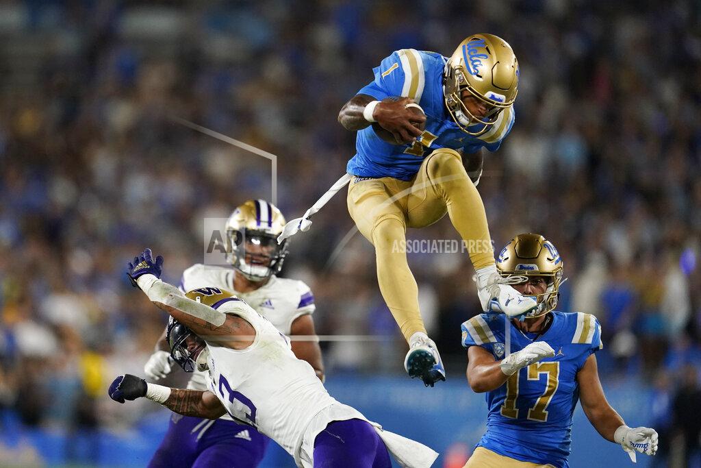 Marcio Jose Sanchez UCLA quarterback Dorian Thompson-Robinson, top, leaps over Washington linebacker Kamren Fabiculanan during the first half of an NCAA college football game Friday, Sept. 30, 2022, in Pasadena, Calif. (AP Photo/Marcio Jose Sanchez)