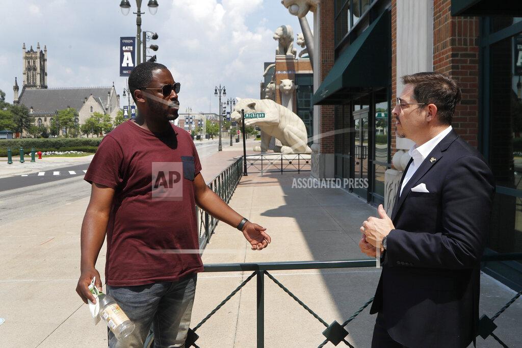 Carlos Osorio Kenny Valentino, left, manager of Delmar, a rooftop business in Greektown, and Adrian Tonon, the 24-Hour Economy Ambassador for Detroit Mayor Mike Duggan, talk, Wednesday, July 8, 2020, in Detroit. Bars and restaurants in the area are desperately hoping people come watch games in nearly empty ballparks on TV in establishments as packed as possible with social distancing guidelines. "The real fans will still want to come out and be around other fans and not just watch the games at home," Valentino said. (AP Photo/Carlos Osorio)