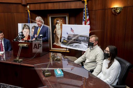 Jeffrey Franz and his wife Brandi listen as attorney Geoffrey Fieger holds a news conference at his offices in Southfield, Mich., Thursday, Dec. 9, 2021. The Franz' daughter, Riley Franz, was shot in the neck while standing next to her sister Bella during the attack. Two lawsuits seeking $100 million each have been filed against a Michigan school district, its superintendent and others after four students were fatally shot and others wounded at Oxford High School. (David Guralnick/Detroit News via AP)