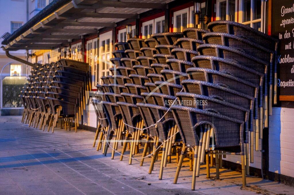 Michael Probst Chairs are piled up outside a restaurant in Haffkrug at the Baltic Sea, Germany, Monday, Jan. 4, 2021. To avoid the outspread of the new coronavirus all restaurants in Germany are closed. (AP Photo/Michael Probst)