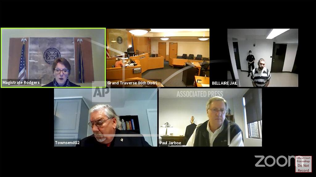 Uncredited In this screen grab from live stream video, Shawn Fix, top right, appears from the Bellaire (Mich)., Country Jail during a virtual hearing before Magistrate Tammi Rodgers, top left, at the Grand Traverse 86th District Court., on Oct. 9, 2020, in Traverse City, Mich. Bottom left, is Assistant Attorney General at the Michigan Attorney General's office Gregory J. Townsend, and Attorney Paul Jarboe, bottom left, representing Shawn Fix from the Michigan Indigent Defense Commission. Fix is charged with terrorists acts and violating federal firearms laws. His attorney entered a not guilty plea on his behalf and bond was set at $250,000.(Grand Traverse 86th District Court via AP)