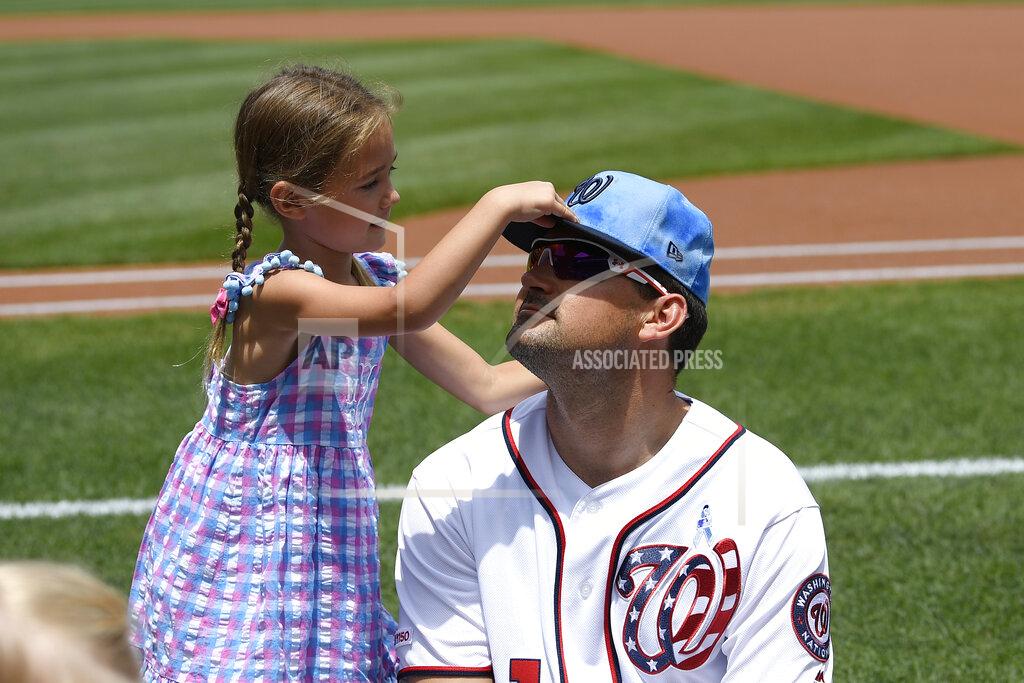 Nick Wass FILE - In this June 16, 2019, file photo, Washington Nationals' Ryan Zimmerman has his cap adjusted by his daughter Mackenzie before a baseball game against the Arizona Diamondbacks in Washington. With baseball on hold because of the coronavirus pandemic, Zimmerman occasionally will offer his thoughts via diary entries published by the AP, while waiting for the 2020 season to begin. (AP Photo/Nick Wass, File)