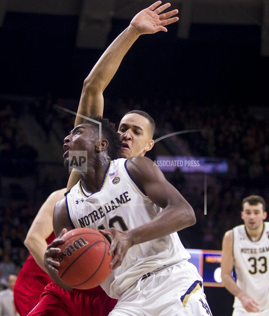 Robert Franklin Notre Dame's T.J. Gibbs Jr., front, moves by North Carolina State's Jericole Hellems during the second half of an NCAA college basketball game Saturday, Jan. 19, 2019, in South Bend, Ind. North Carolina State won 77-73. (AP Photo/Robert Franklin)