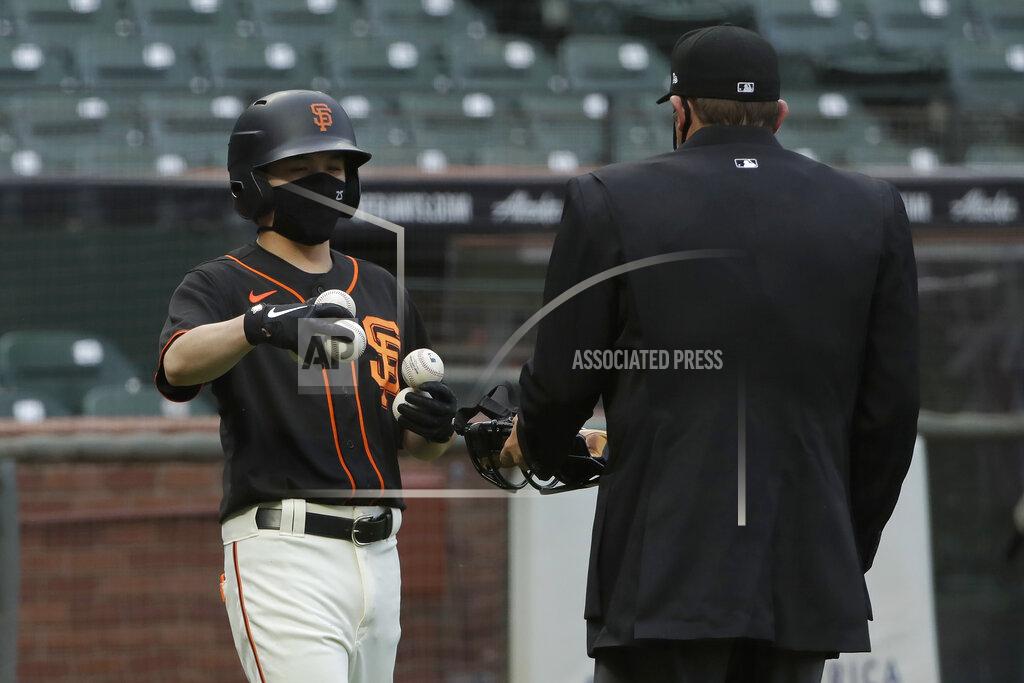Jeff Chiu San Francisco Giants ball kid Austin Ginn, left, brings balls to umpire Brian Knight during the first inning of an exhibition baseball game between the Oakland Athletics and the Giants in San Francisco, Tuesday, July 21, 2020. (AP Photo/Jeff Chiu)
