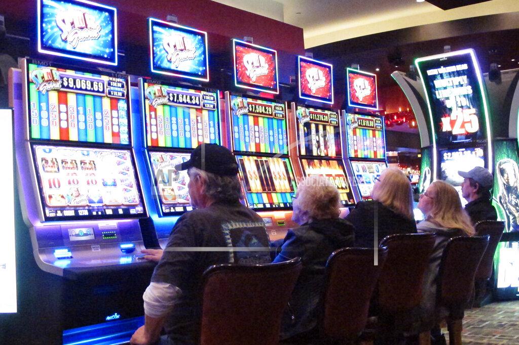 Wayne Parry In this Feb. 22, 2019 photo, gamblers play slot machines in the Golden Nugget Casino in Atlantic City, N.J. Every second or third slot machine might be turned off or made inaccessible in some casinos as they adapt to the coronavirus outbreak in preparing to reopen. Many casinos plan more frequent sanitization of slot machines once they reopen. (AP Photo/Wayne Parry)