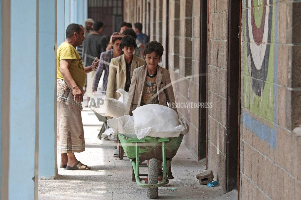 Hani Mohammed In this Aug. 25, 2019, file photo, displaced Yemenis receive food supplies provided by the World Food Programme, at a school in Sanaa, Yemen. The World Food Program chief warned Thursday, Sept. 17, 2020, that millions of people are closer to starvation because of the deadly combination of conflict, climate change and the COVID-19 pandemic and he urged donor nations and billionaires to help feed them and ensure their survival. (AP Photo/Hani Mohammed, File)