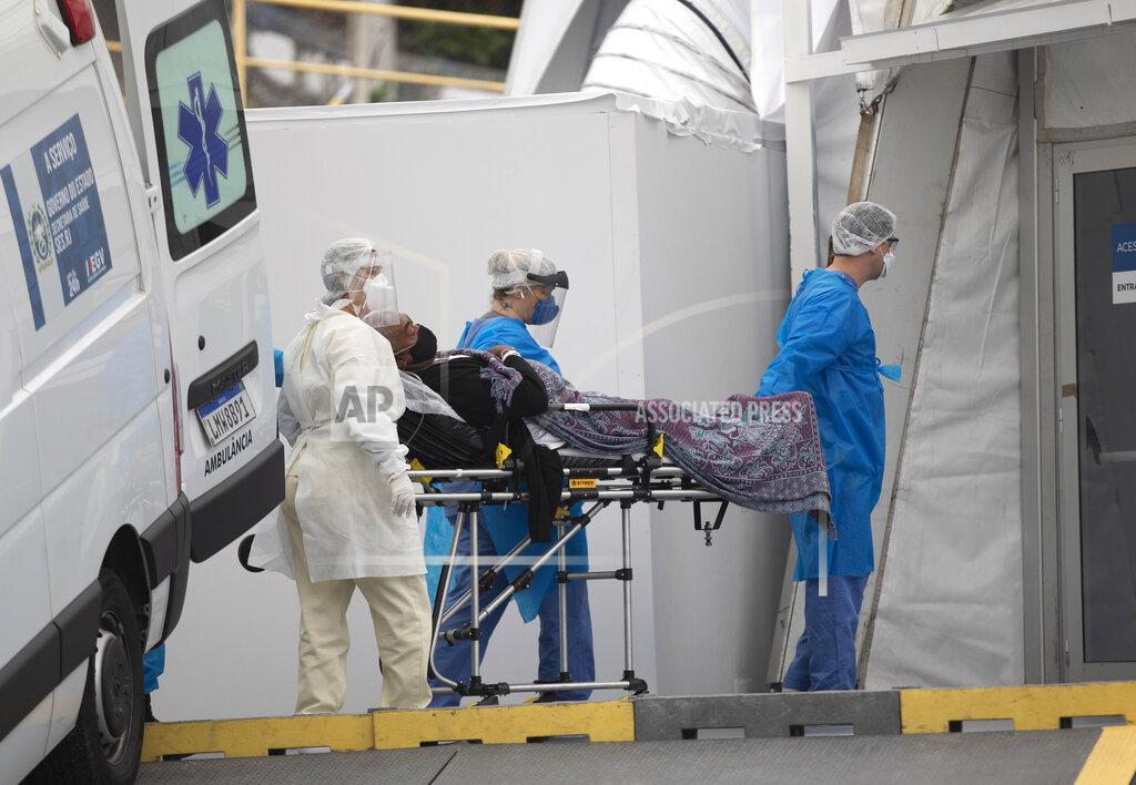 Silvia Izquierdo A patient with symptoms related to COVID-19 is brought to a field hospital by workers in full protective gear in Leblon, Rio de Janeiro, Brazil, Thursday, June 4, 2020. (AP Photo/Silvia Izquierdo)