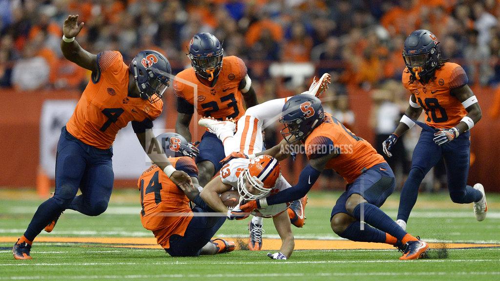 Clemson wide receiver Hunter Renfrow (13) is upended by Syracuse defensive back Evan Foster (14) and defensive back Jordan Martin (2) during the first half of an NCAA college football game, Friday, Oct. 13, 2017, in Syracuse, N.Y. (AP Photo/Adrian Kraus)